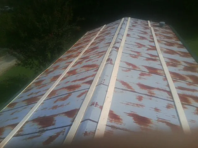 Rusted metal roof panels with new wood purlins before replacement — Storm Damage Roof Repair in Carthage by Roofing Brothers