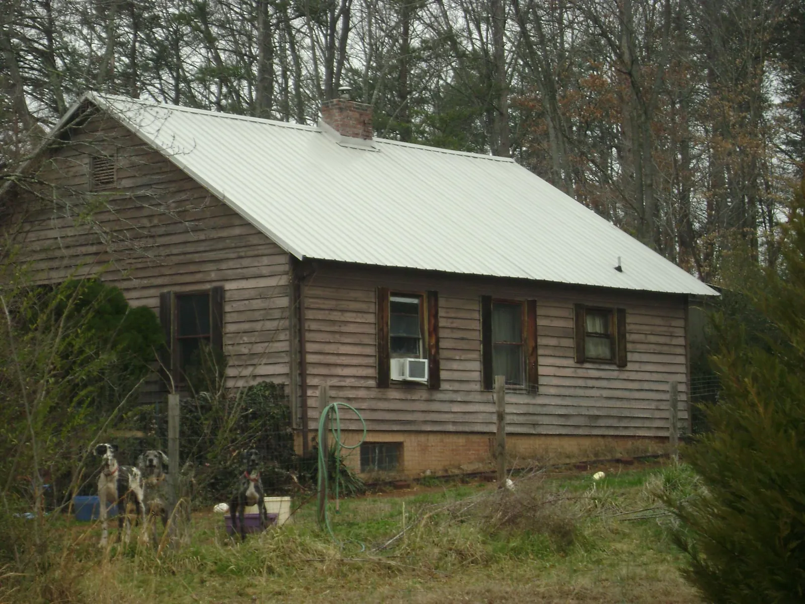 White metal roof on an old wood sided farmhouse, from a Metal Roof Installation job in Carthage